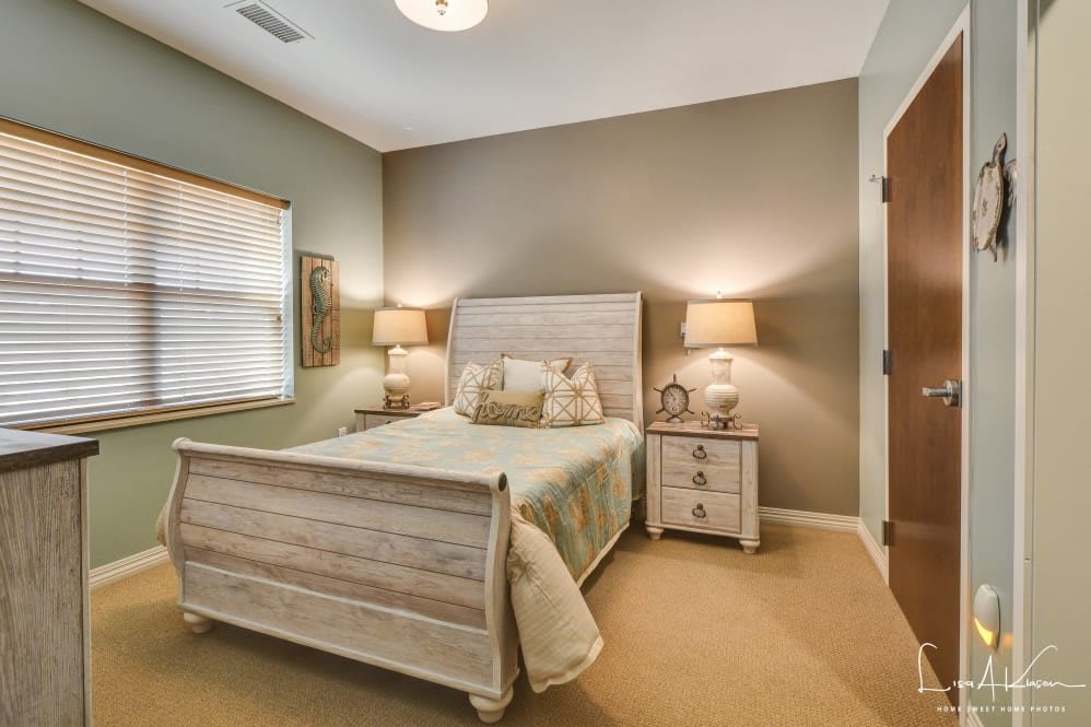 A cozy bedroom with a rustic bed, two nightstands, and warm lighting.