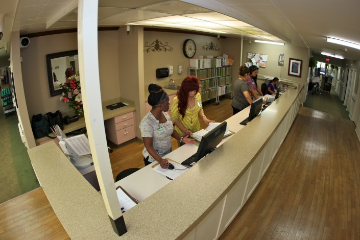 A busy office reception area with employees working at their desks.