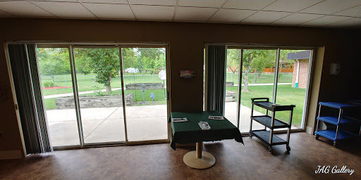 Cozy indoor space with a green tablecloth and a view of the outdoors through sliding doors.