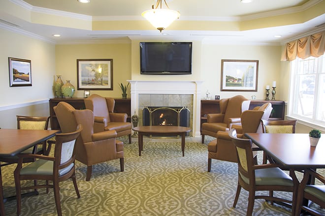 A cozy living room with a fireplace, TV, and comfortable seating arrangement.