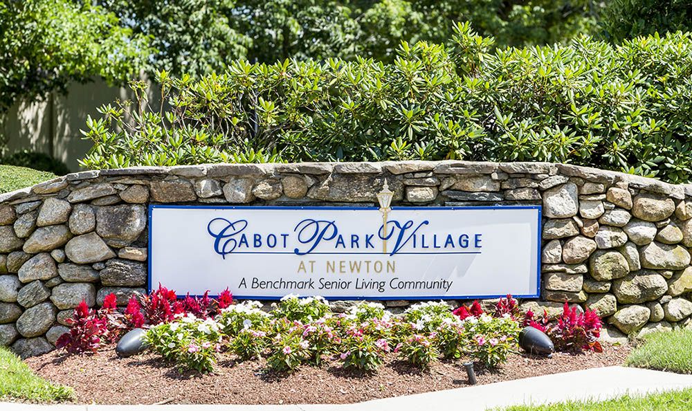 Sign for Cabot Park Village at Newton, surrounded by a landscaped garden.