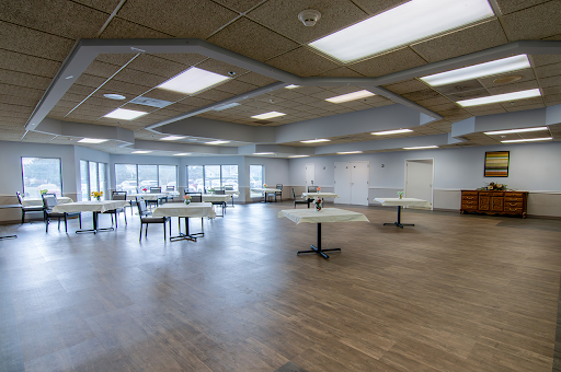 A spacious and modern event space featuring tables and ample natural light.