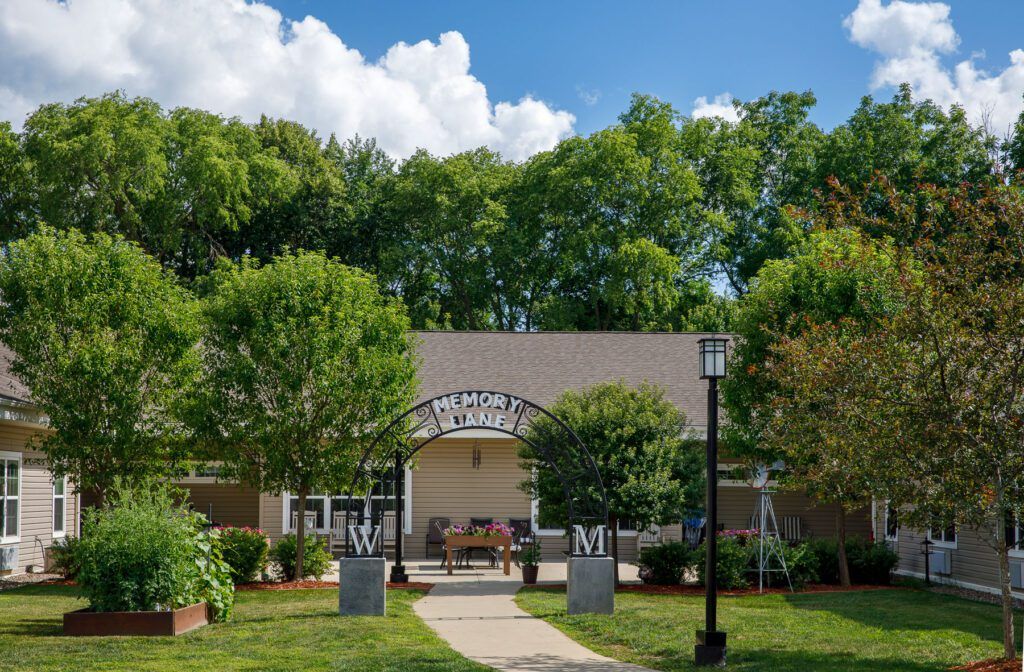 A building surrounded by trees with a clear sky above and a pathway leading up to it.
