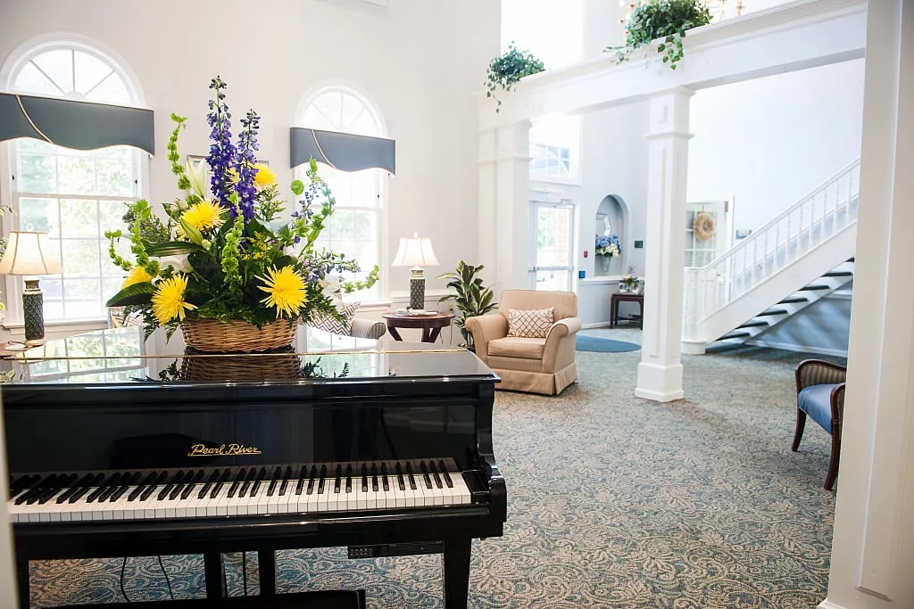 A cozy living room with a grand piano and elegant decor.