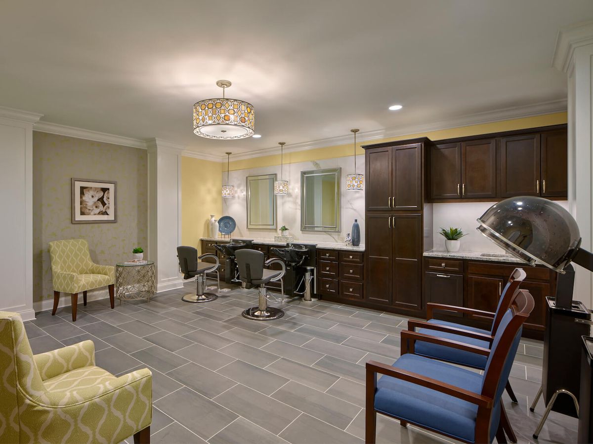 A modern salon interior featuring stylish chairs, mirrors, and elegant lighting.
