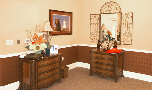 A stylishly decorated corner featuring elegant furniture, a mirror, and decorative elements.