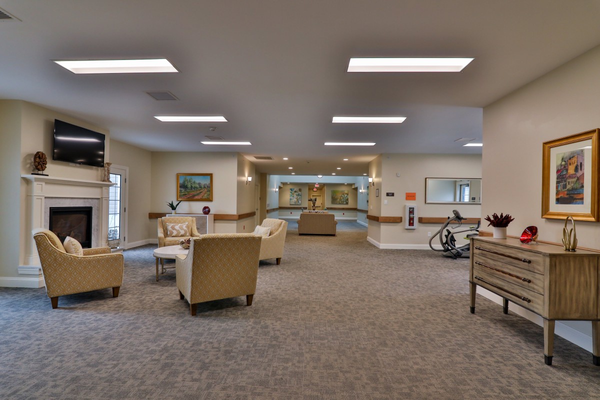 A spacious lobby area with comfortable seating, artwork on the walls, and overhead lighting.