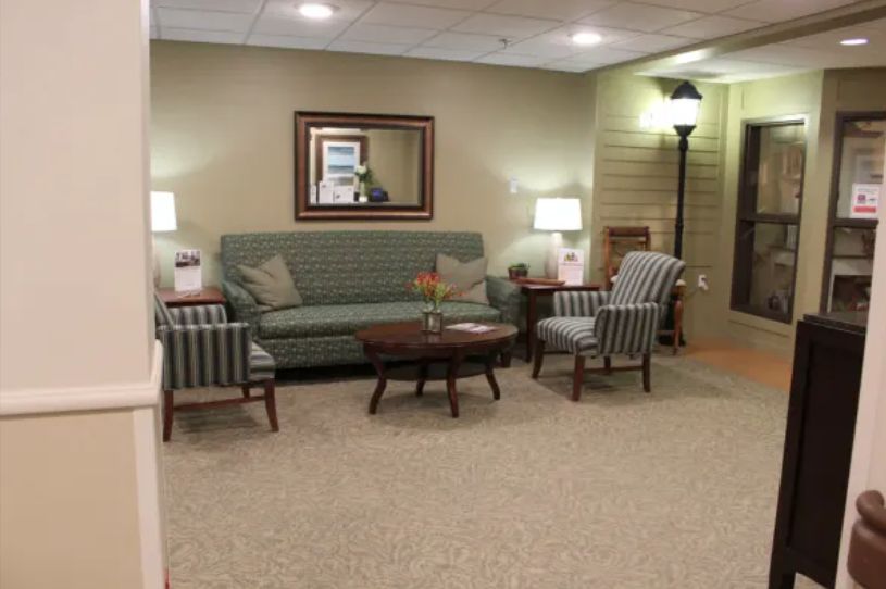 A cozy living room featuring a sofa, chairs, a coffee table, and lamps under soft lighting.