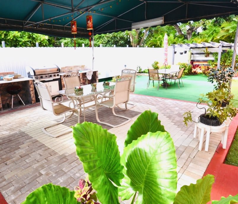 A cozy outdoor patio area with seating and lush greenery.