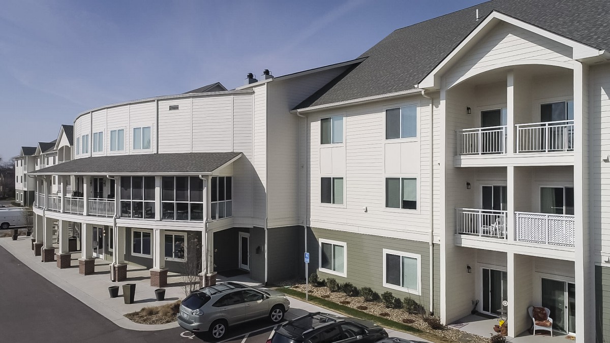 A modern apartment building with parked cars outside.
