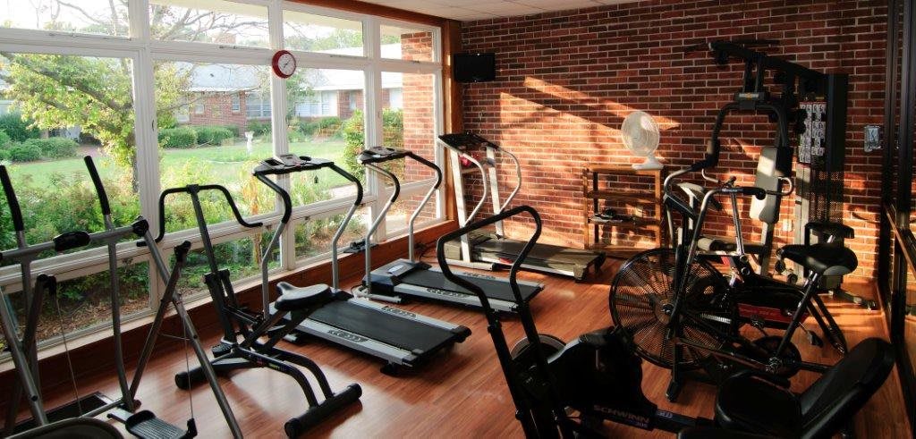 A cozy gym room with treadmills and exercise equipment.