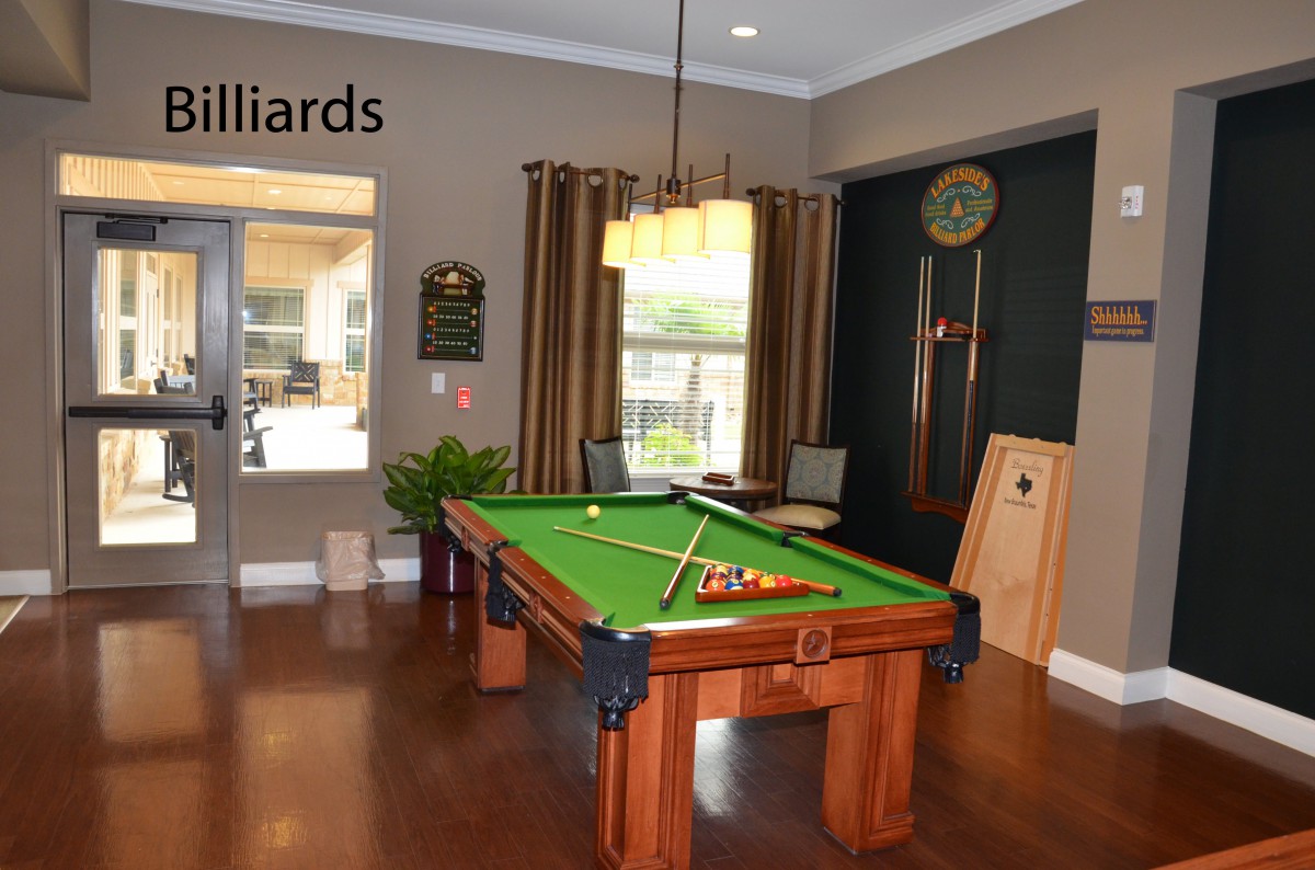 A cozy billiards room with a pool table and seating arrangement.