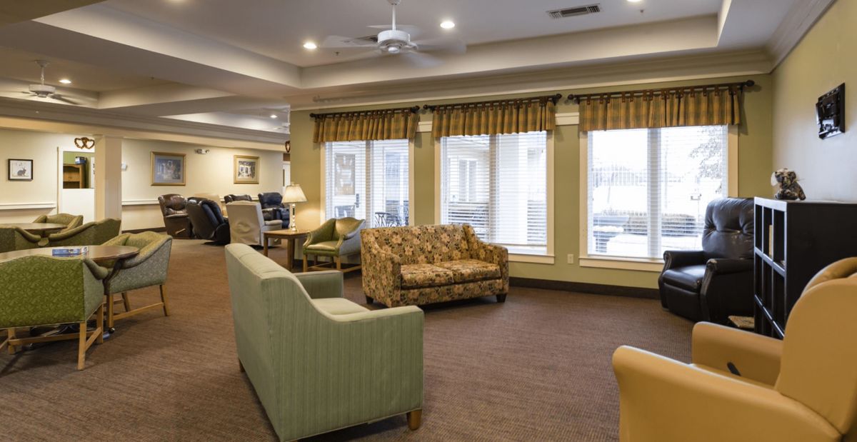 A cozy living room with various sofas, large windows, and ambient lighting.