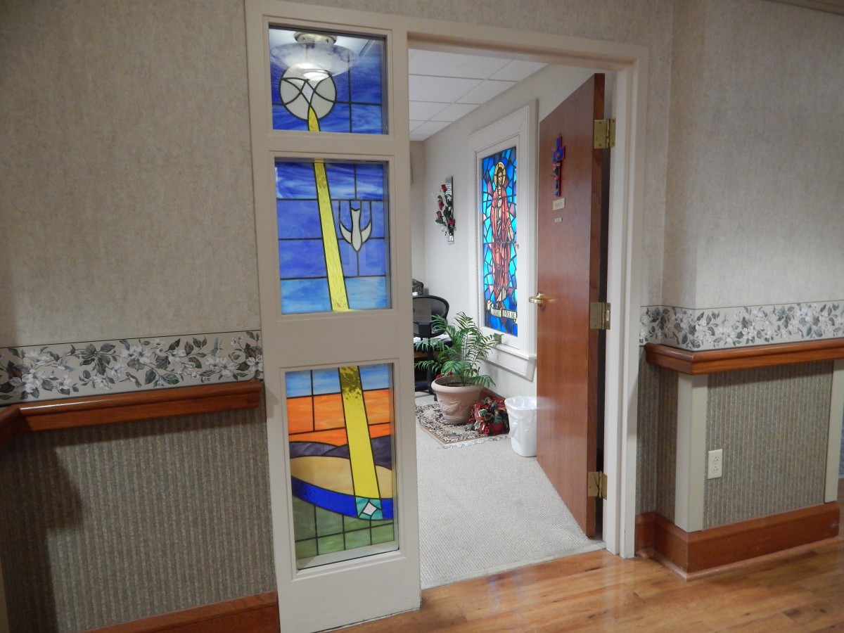 A corridor featuring a door with vibrant stained glass panels.
