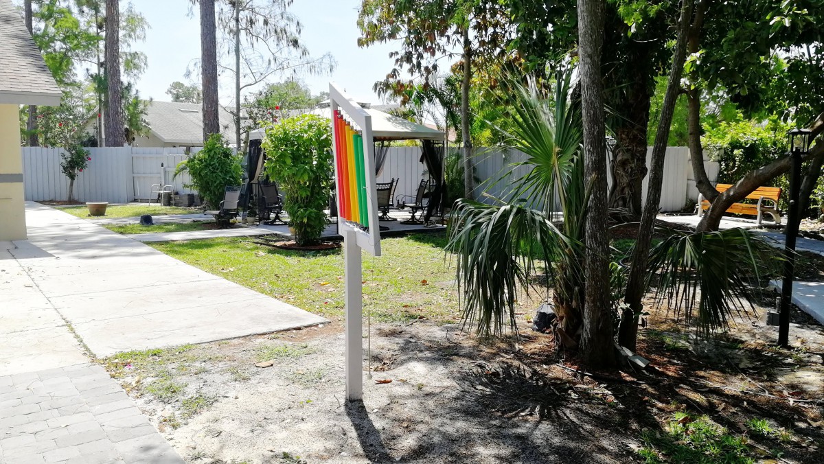 Outdoor colorful sculpture creating an optical illusion in a park setting.