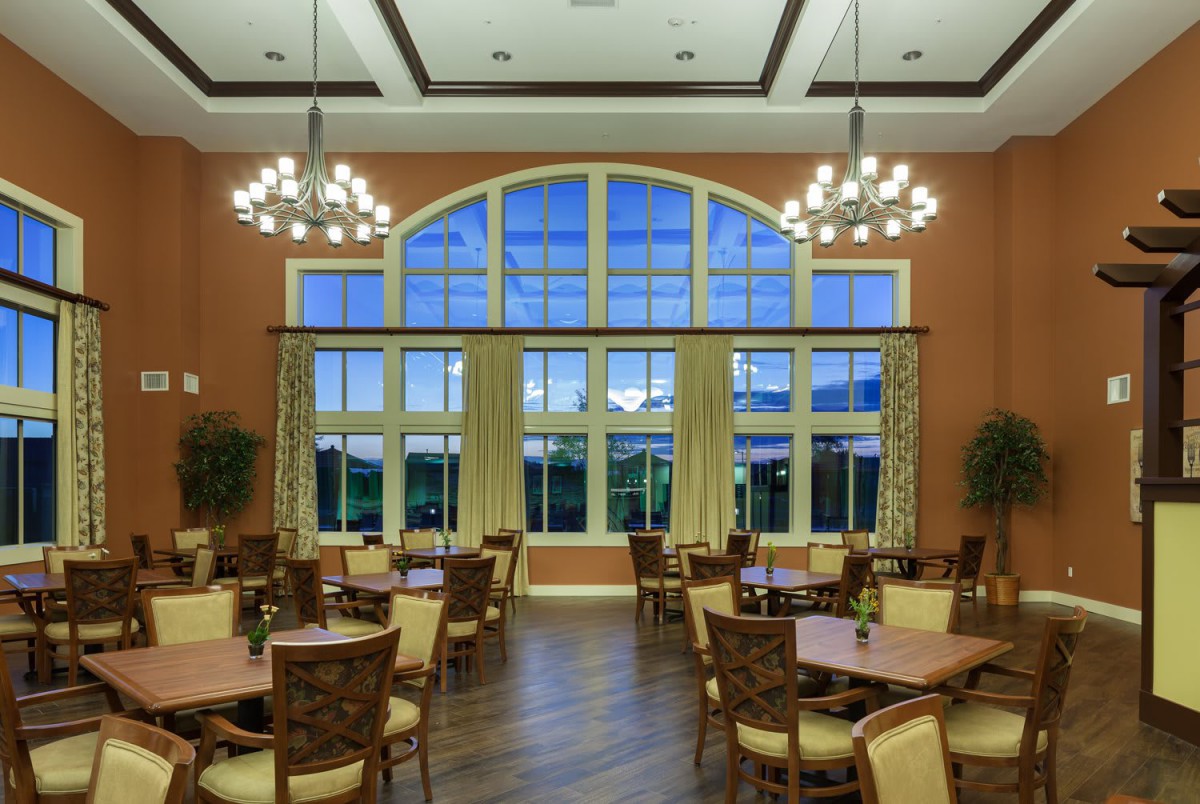 An elegantly designed dining room with large windows and chandeliers.