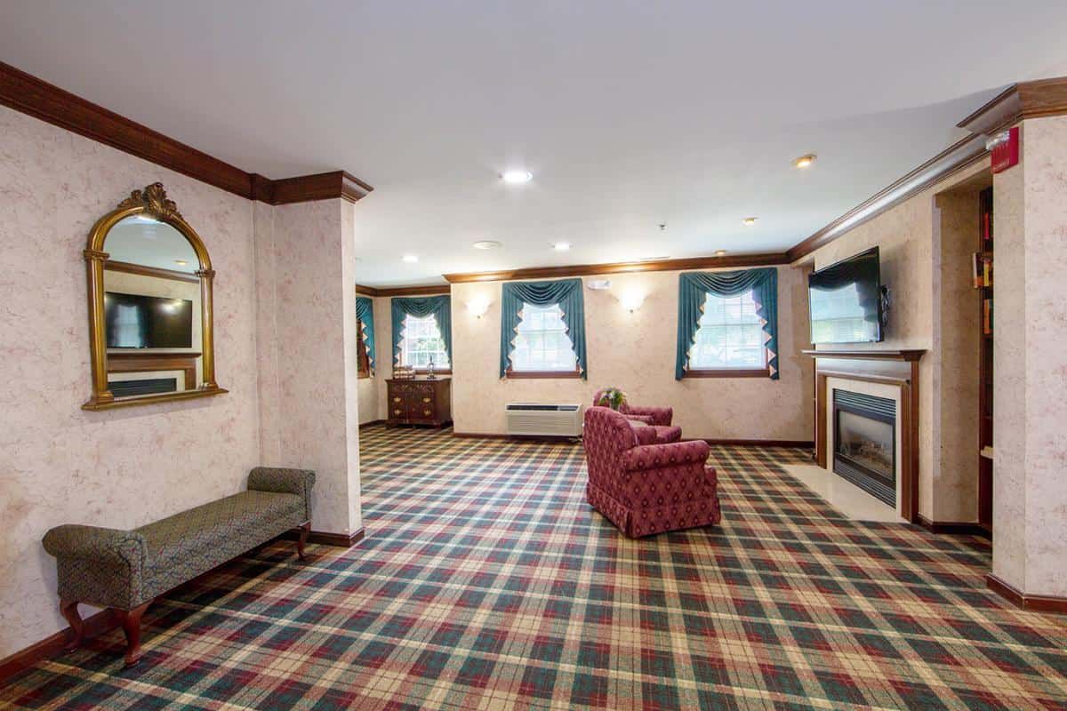 A traditional living room with plaid carpet and comfortable seating.