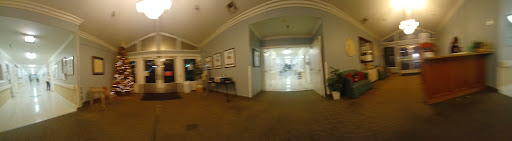 A view of a well-lit hallway with artwork on the walls, leading to a brighter area.