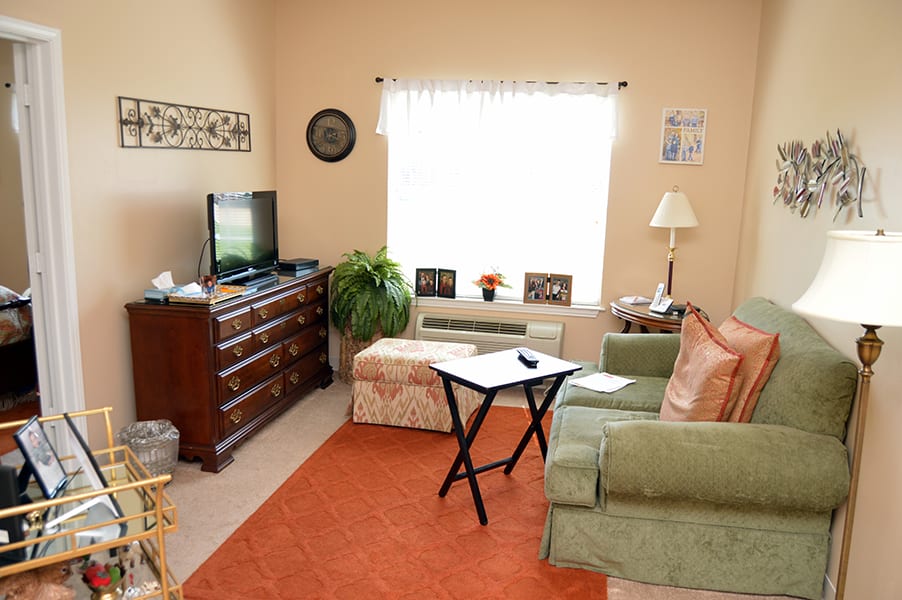 A cozy living room with a sofa, television, and various decorations.