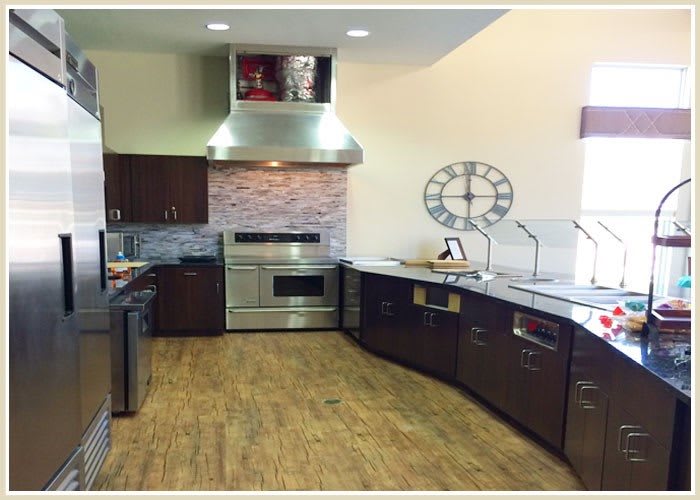 A modern kitchen with sleek cabinetry, stainless steel appliances, and wood flooring.