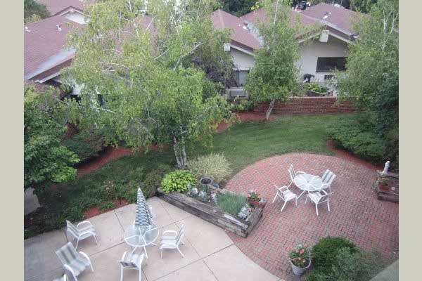 A peaceful backyard patio area with outdoor seating and lush greenery.