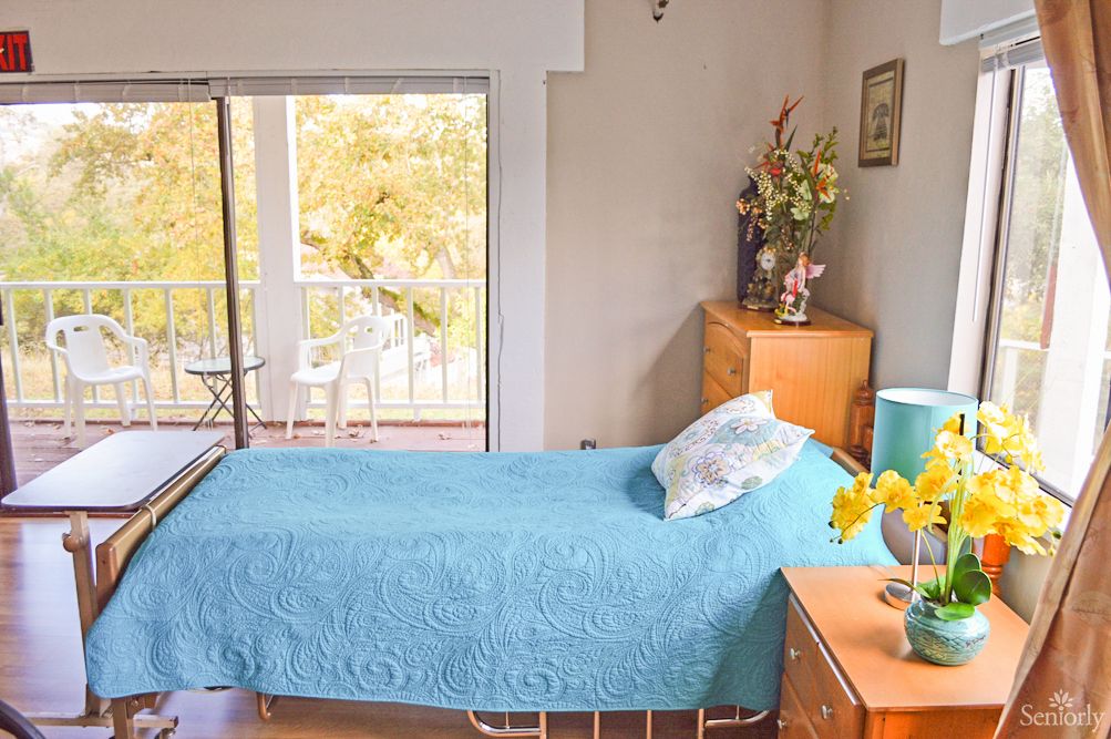A cozy bedroom with a single bed and a view of the balcony.