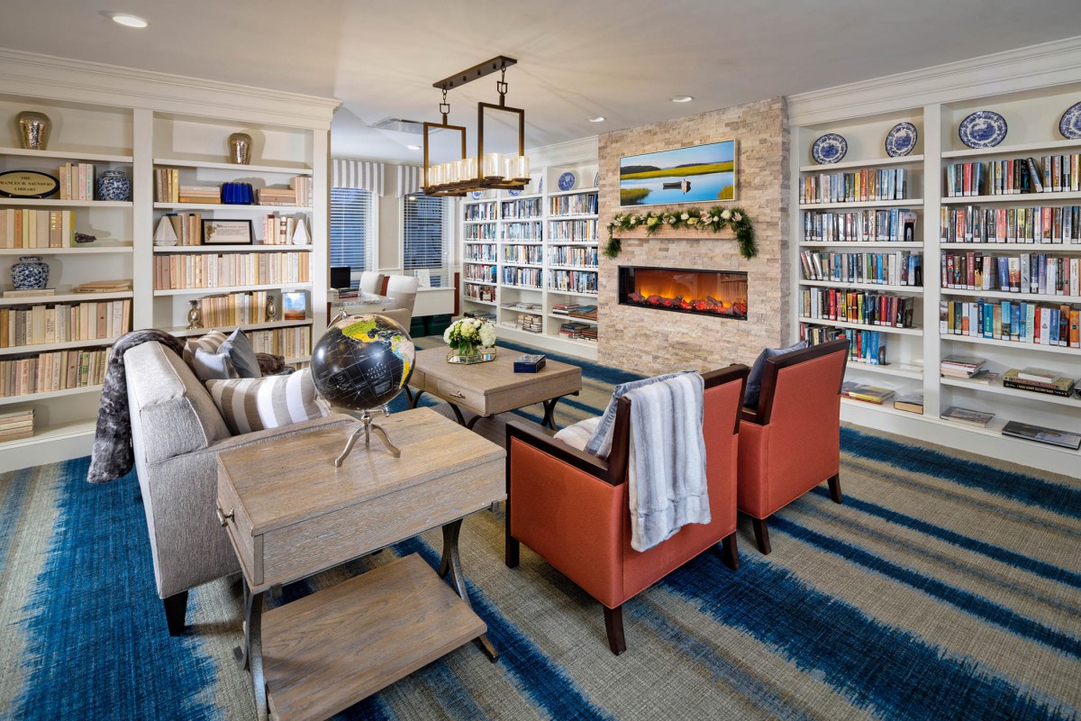 Cozy living room with bookshelves, a fireplace, and comfortable seating.