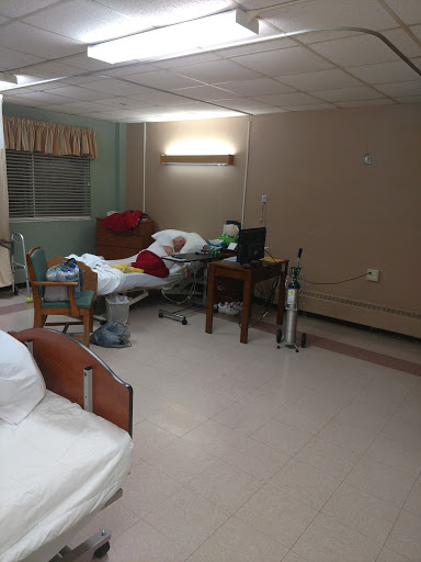 A view of a hospital patient room with an unoccupied bed and medical equipment.