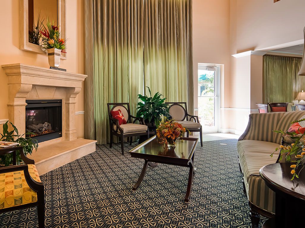 A cozy living room with elegant furniture, a fireplace, and large curtains.