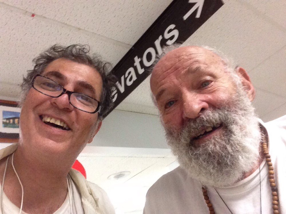 Two people taking a selfie under an elevator sign.