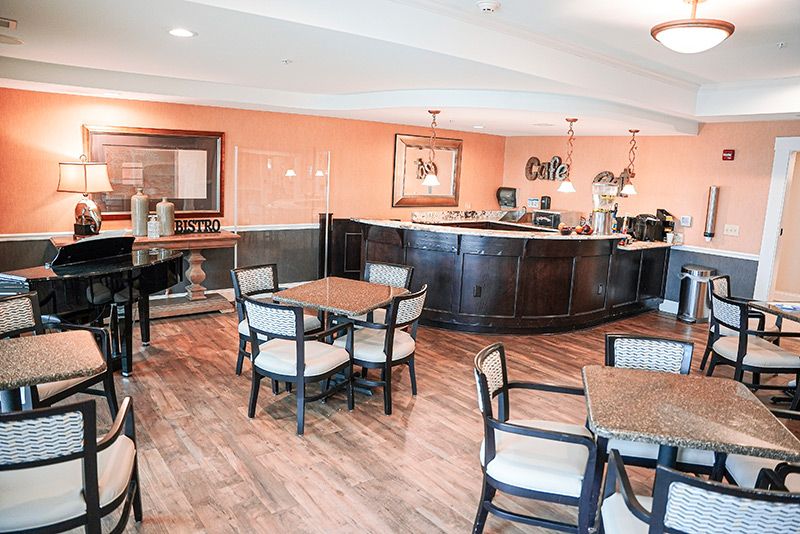 A cozy cafe interior with tables, chairs, and a serving counter.