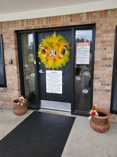 A festive entrance adorned with a colorful fall wreath and potted plants.