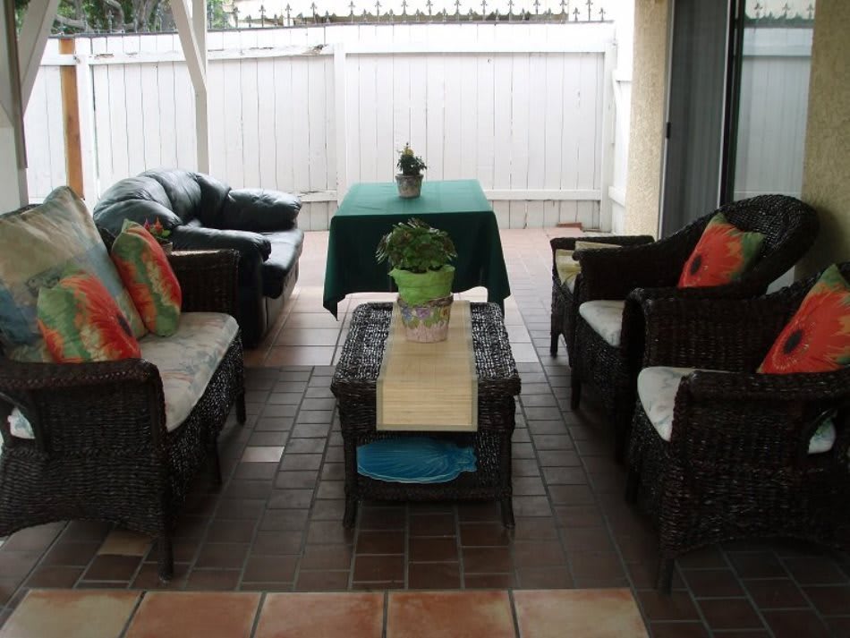 A cozy patio seating area with wicker furniture and colorful cushions.