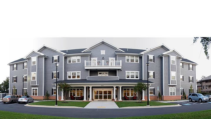 A modern residential building with a symmetrical facade and multiple windows.