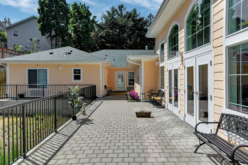 A spacious outdoor patio area with potted plants and large glass doors.