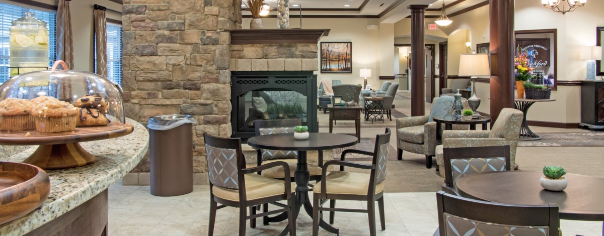 A cozy seating area with a round table and chairs near a stone fireplace.