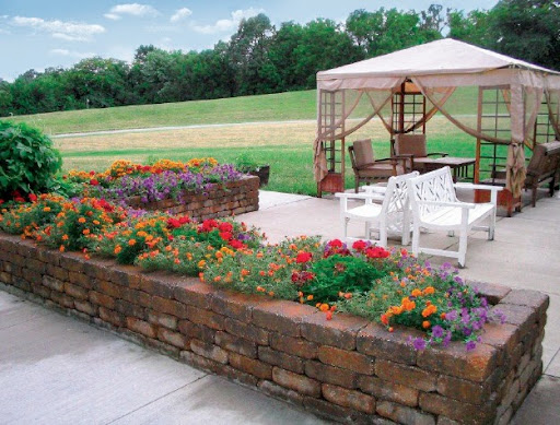 A beautifully landscaped garden featuring vibrant flowers and a cozy outdoor seating area.