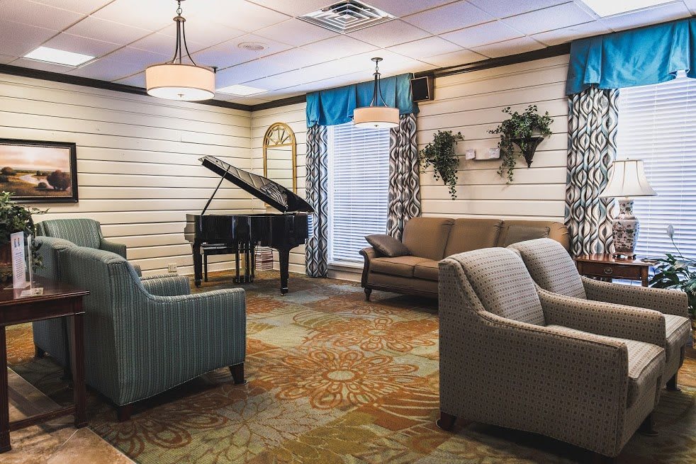 A cozy lounge area featuring a grand piano and comfortable seating.