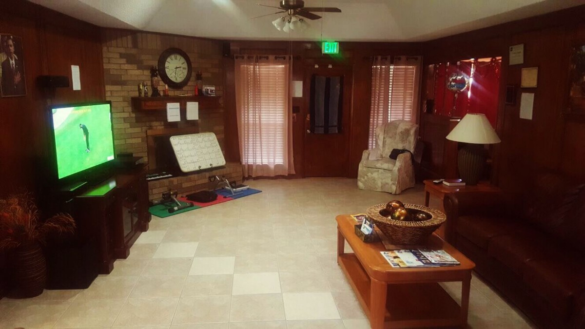 A cozy living room with a coffee table, chair, and wall clock.