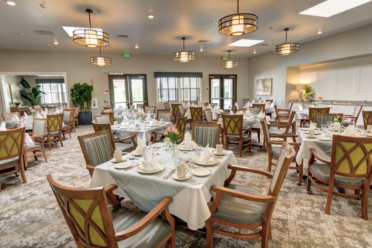 An elegantly set dining room with multiple tables and chairs, ready for service.