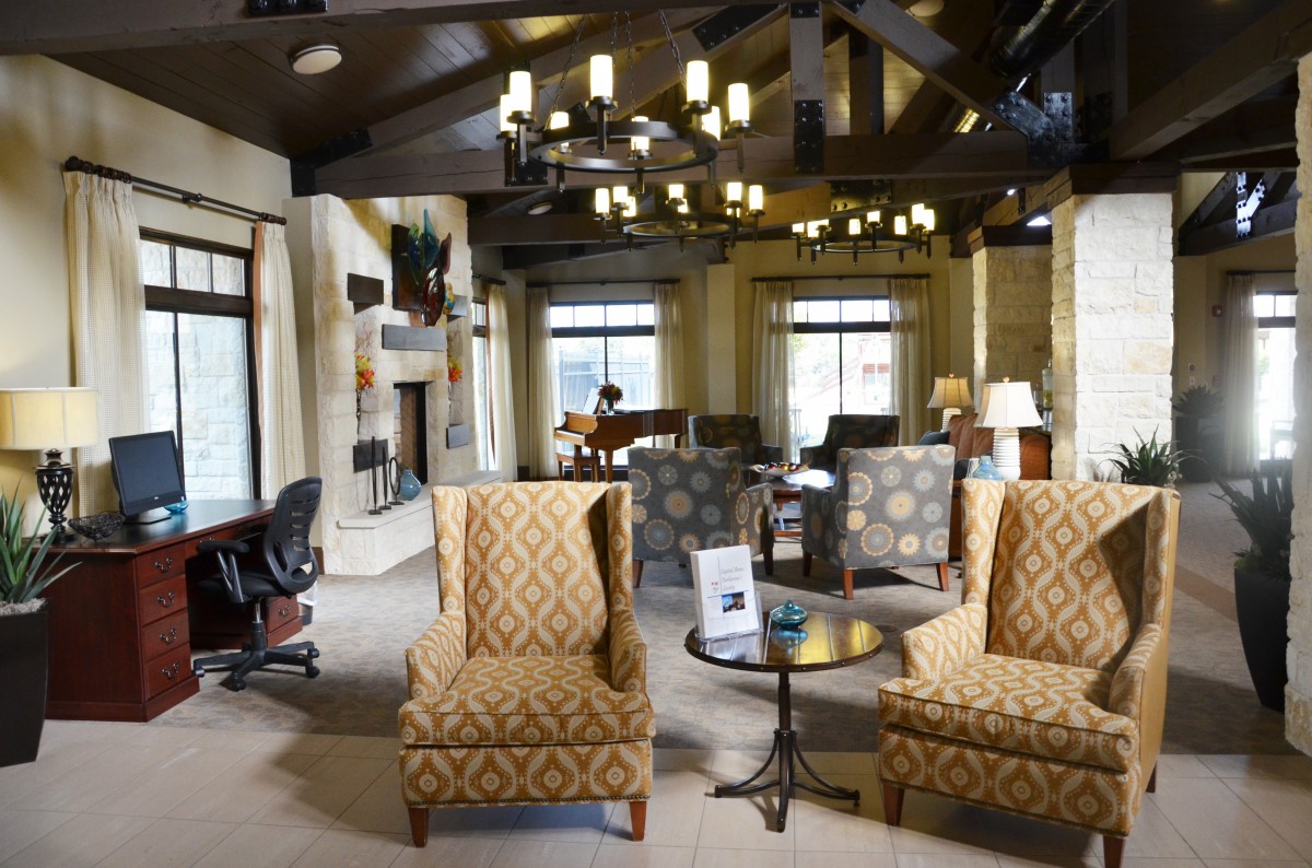 A spacious lounge area with comfortable seating and elegant chandeliers.