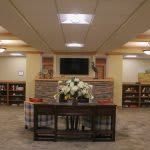 A cozy living room with a TV, bookshelves, and comfortable seating.