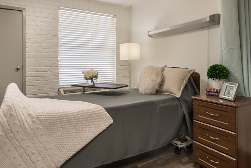 A cozy and modern bedroom featuring a neatly made bed, stylish lamp, and decorative touches.