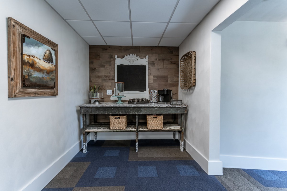 A cozy coffee station set against a brick wall with a mirror and decor.