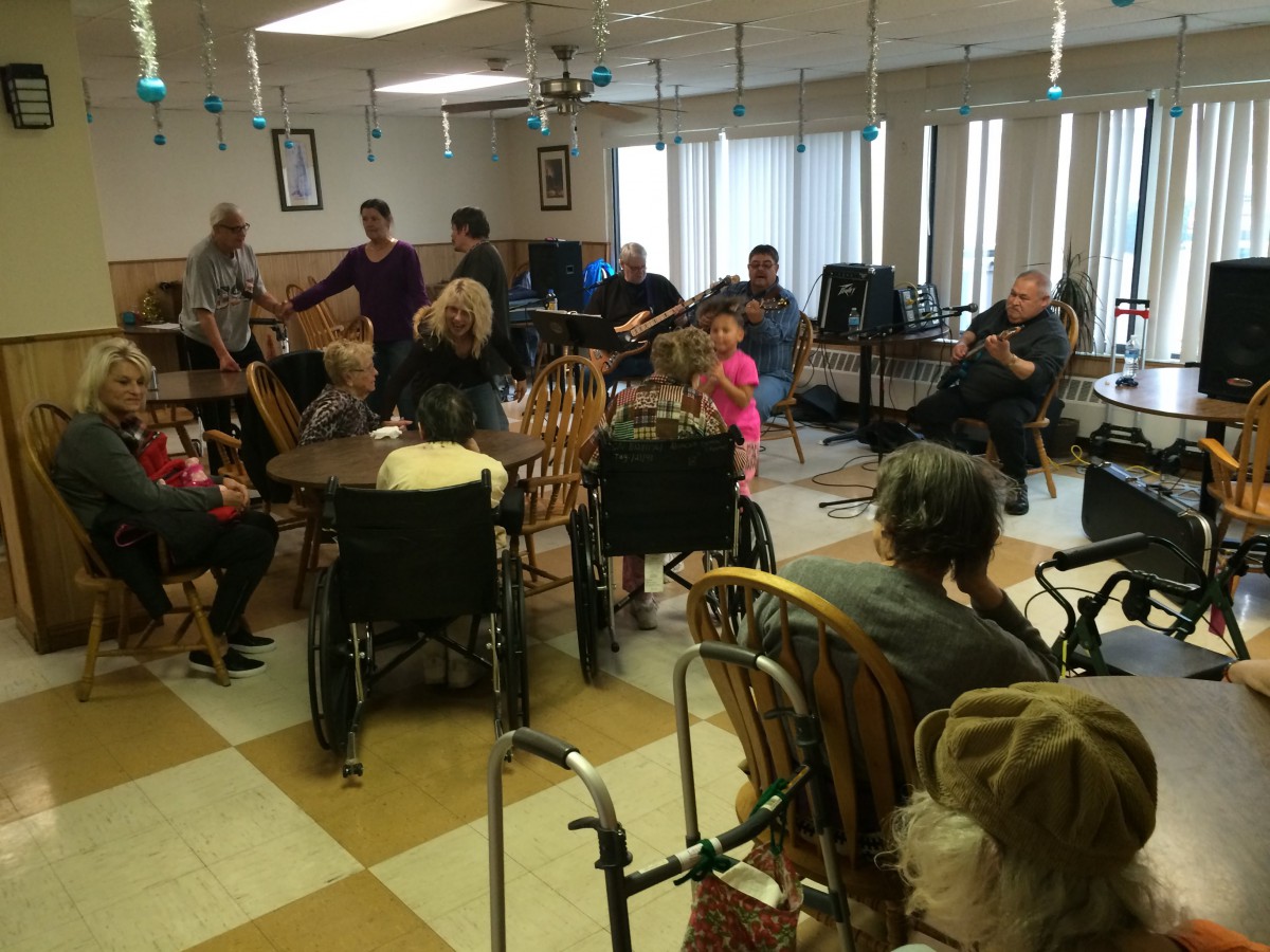 A group of elderly individuals in a nursing home setting, engaging in community activities.