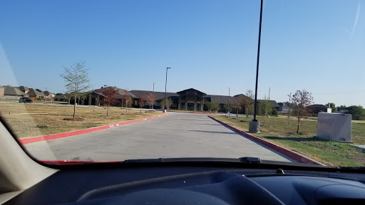 View of a building from the perspective of a parked car on a clear day.