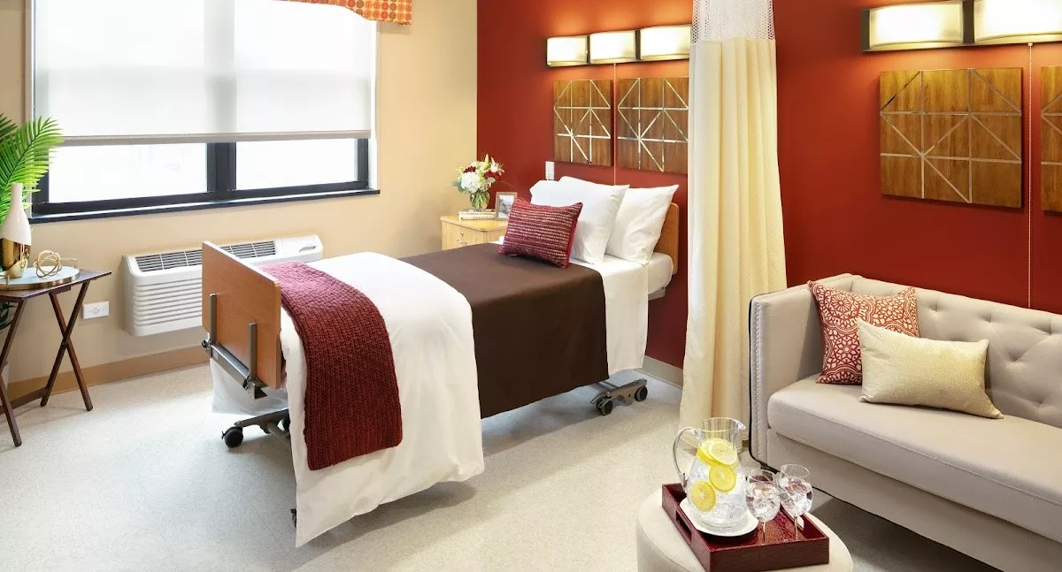 A well-decorated hospital room featuring a comfortable bed, warm lighting, and stylish decor.