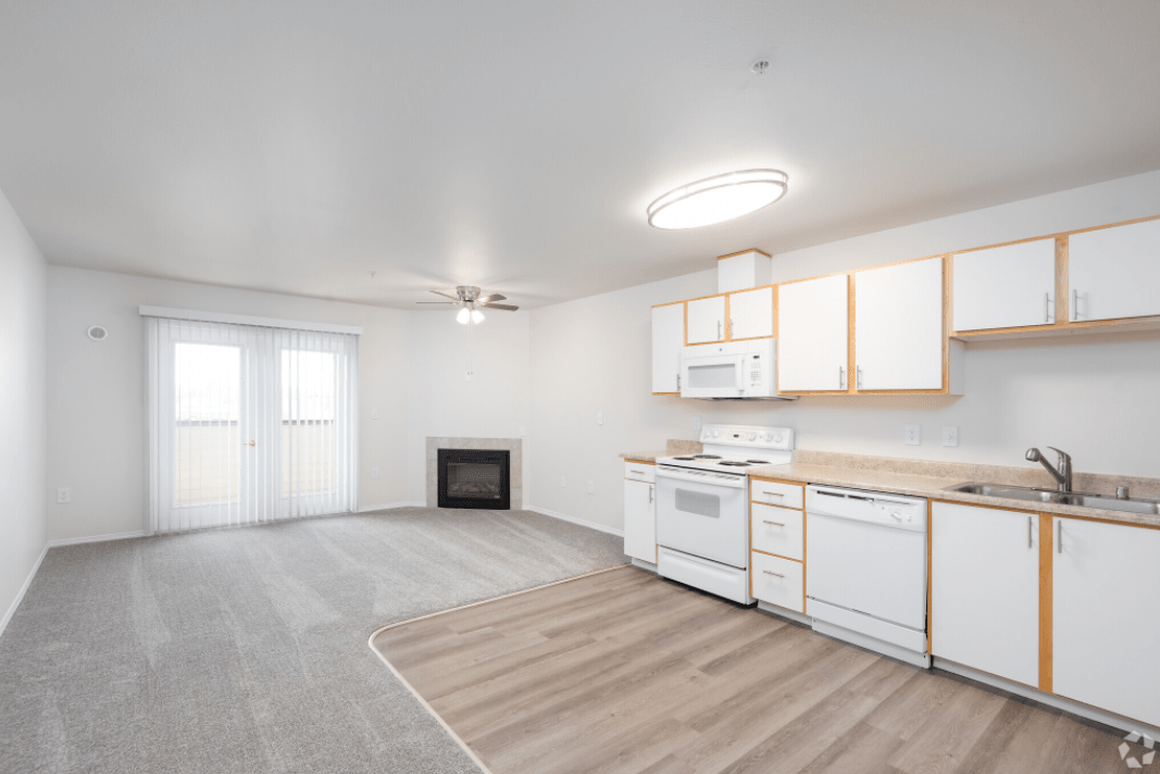 A modern open-space apartment featuring a kitchen and living area with minimalist decor.