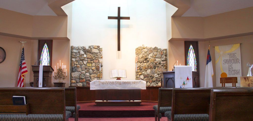 Interior view of a church featuring an altar and a cross.