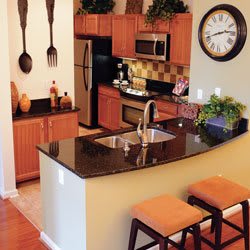 A modern kitchen with a sleek countertop, bar stools, and stylish decor.